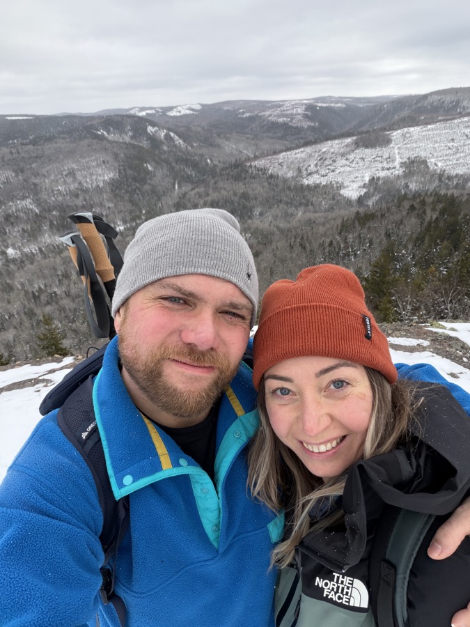 James and a hiking companion overlooking a snowy forest valley